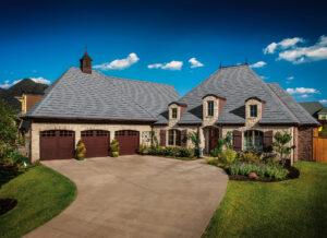 Asphalt shingle roof replacement on a big home with big garage and manicured lawn